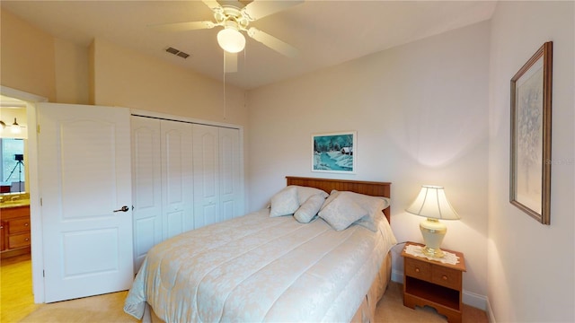 bedroom featuring light colored carpet, a closet, and ceiling fan