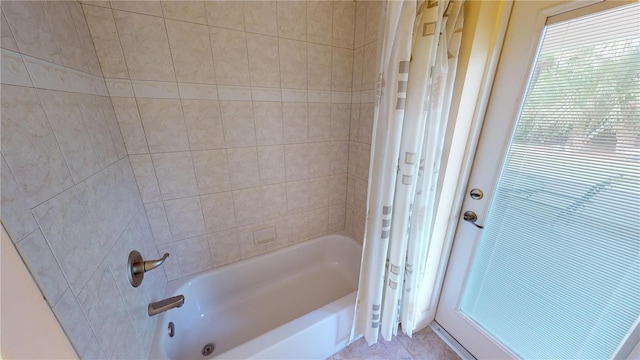 bathroom with tiled shower / bath and tile patterned floors