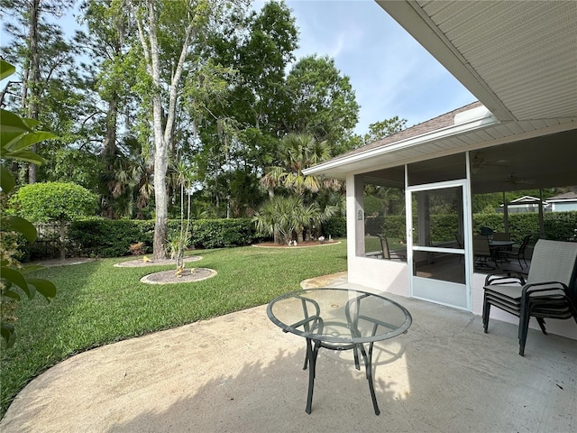 view of patio with a sunroom and ceiling fan