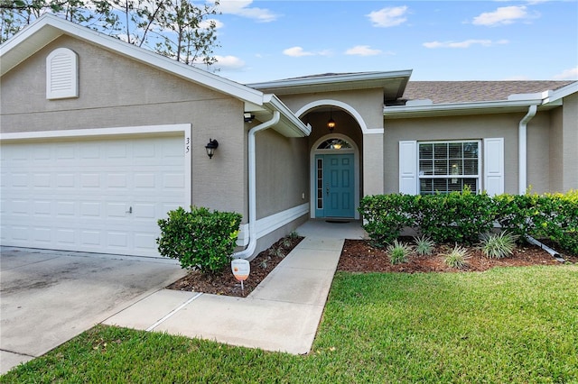 view of exterior entry featuring a yard and a garage