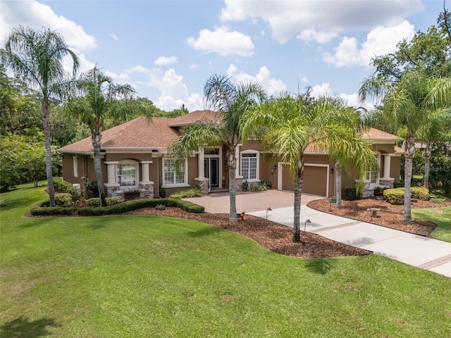 mediterranean / spanish house with a garage and a front lawn