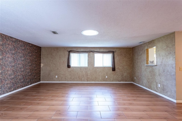 empty room featuring light hardwood / wood-style floors and a textured ceiling