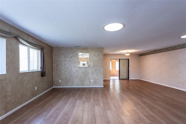 empty room featuring a textured ceiling and hardwood / wood-style floors