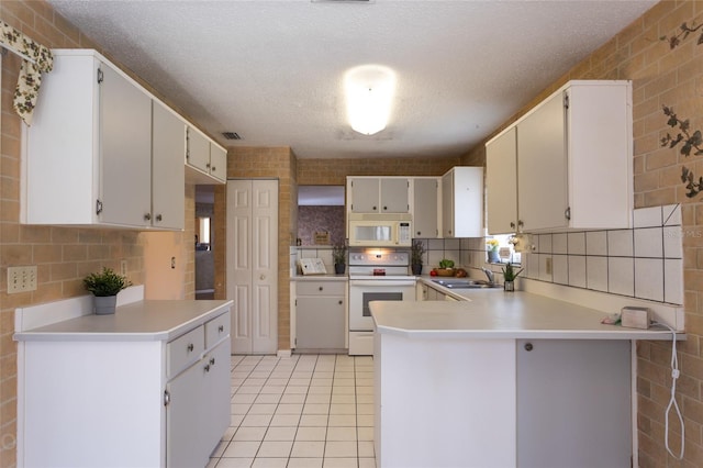 kitchen featuring sink, white cabinetry, kitchen peninsula, and white appliances