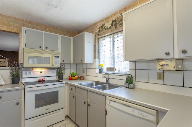 kitchen featuring backsplash, a textured ceiling, light tile patterned flooring, sink, and white appliances