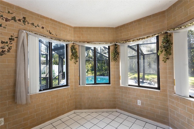 empty room with a textured ceiling and light tile patterned flooring