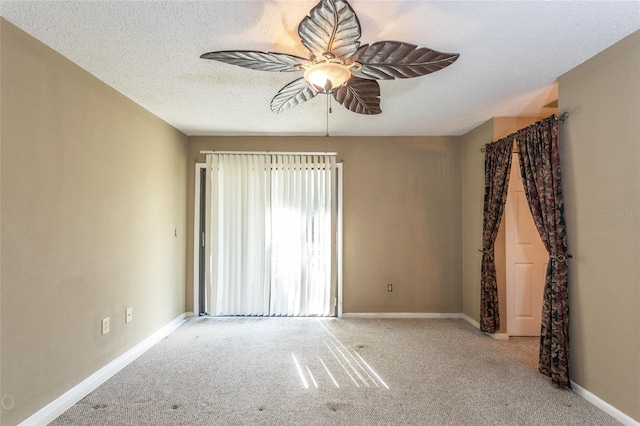 empty room with ceiling fan, light carpet, and a textured ceiling