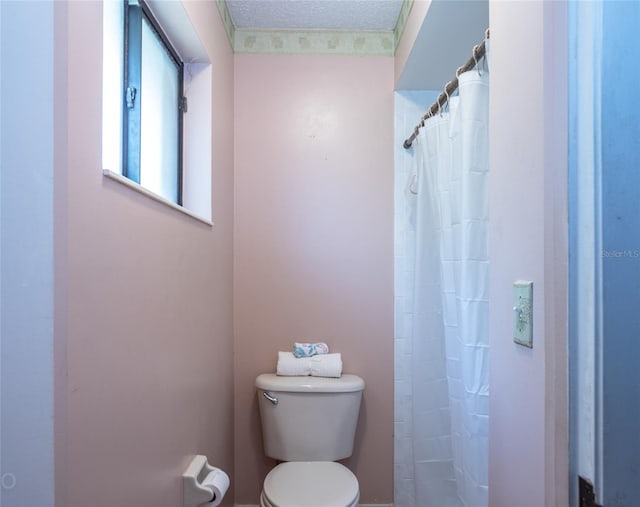 bathroom featuring toilet, a textured ceiling, and walk in shower