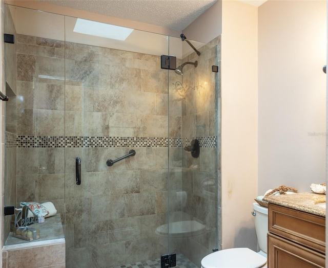 bathroom with vanity, toilet, walk in shower, and a skylight