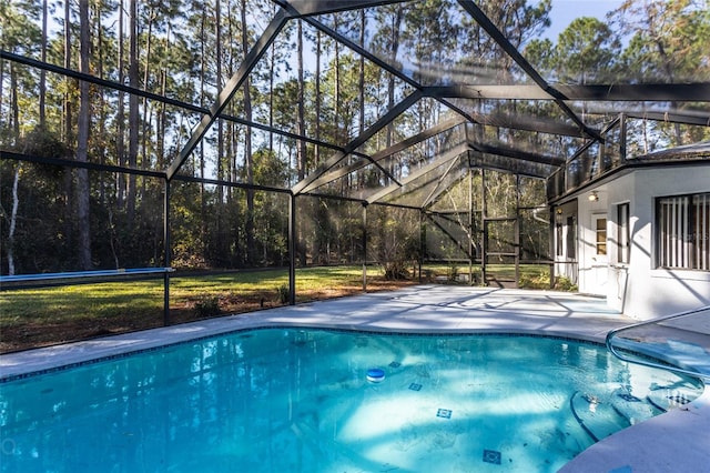 view of swimming pool featuring a yard, a patio, and a lanai