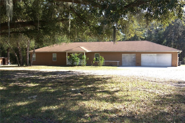 single story home featuring a front yard and a garage