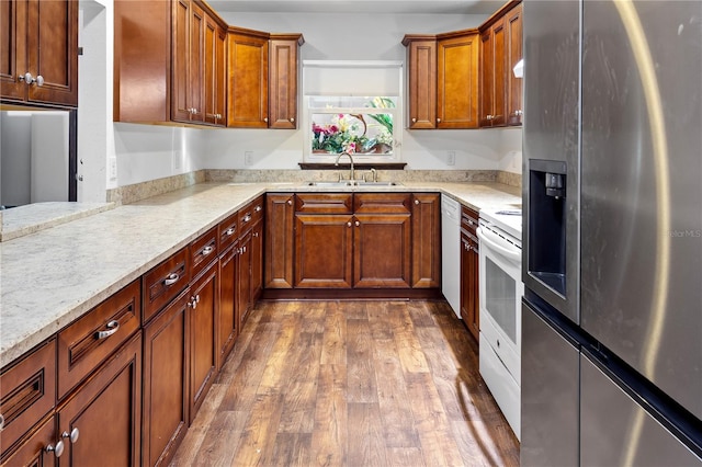 kitchen featuring sink, light stone countertops, white appliances, and dark hardwood / wood-style flooring