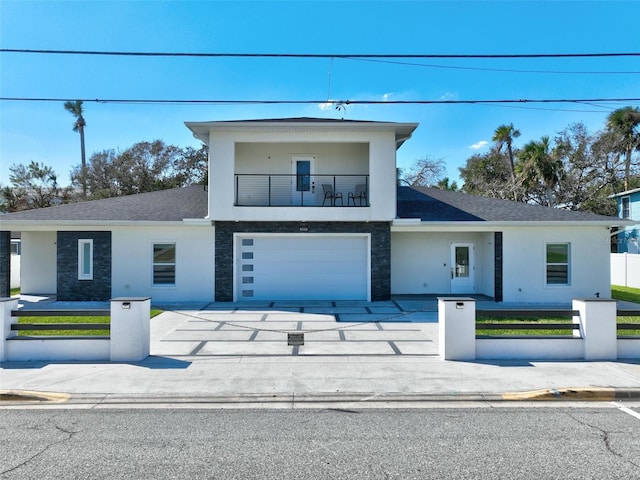 view of front of property featuring a garage and a balcony