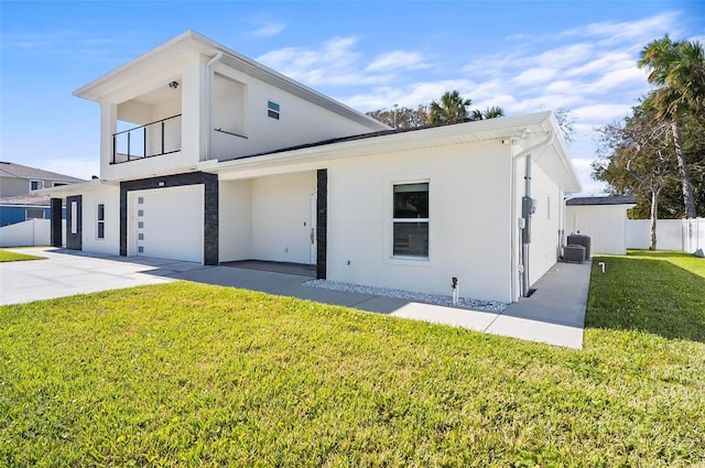 view of front of home featuring a front lawn, a garage, and a balcony