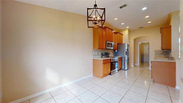 kitchen featuring a notable chandelier, backsplash, light tile patterned flooring, crown molding, and stainless steel appliances