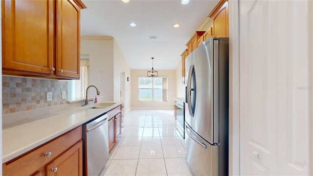 kitchen with tasteful backsplash, light tile patterned floors, sink, pendant lighting, and stainless steel appliances