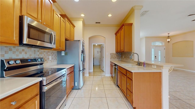 kitchen with backsplash, light tile patterned floors, ornamental molding, sink, and stainless steel appliances