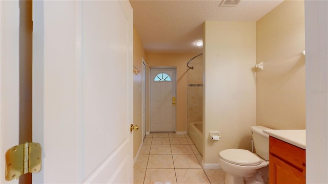 full bathroom with a textured ceiling, toilet, vanity, tiled shower / bath combo, and tile patterned floors