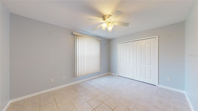 unfurnished bedroom with light tile patterned floors, a textured ceiling, a closet, and ceiling fan