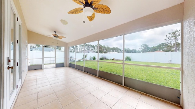 unfurnished sunroom with vaulted ceiling, ceiling fan, and plenty of natural light