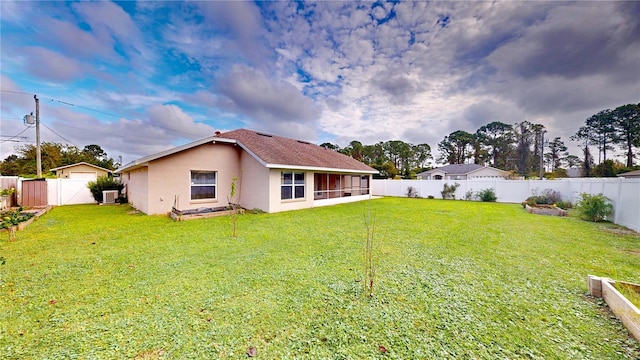 back of property with a yard and central AC unit