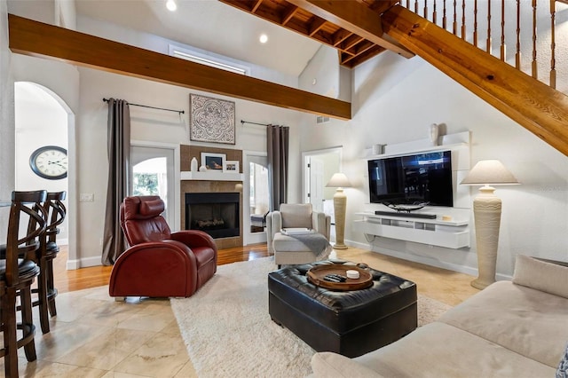 living room with light hardwood / wood-style floors, beam ceiling, and high vaulted ceiling