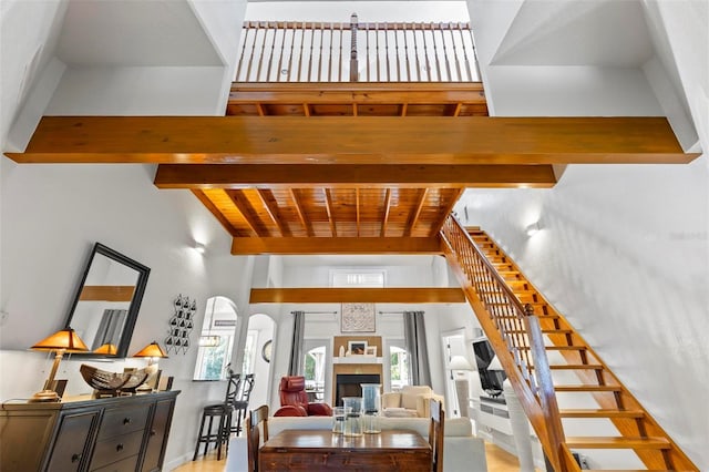 stairway with beamed ceiling and a high ceiling