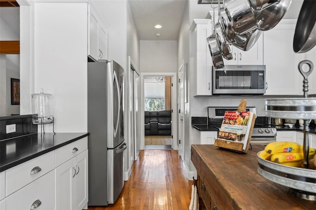 kitchen featuring white cabinetry, stainless steel appliances, light hardwood / wood-style floors, and wood counters