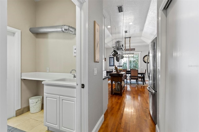 corridor featuring light hardwood / wood-style flooring and a textured ceiling