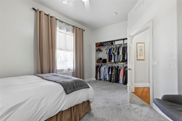 bedroom featuring light colored carpet, a closet, and ceiling fan