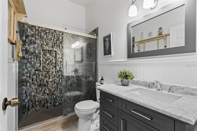 bathroom featuring toilet, an enclosed shower, vanity, and wood-type flooring