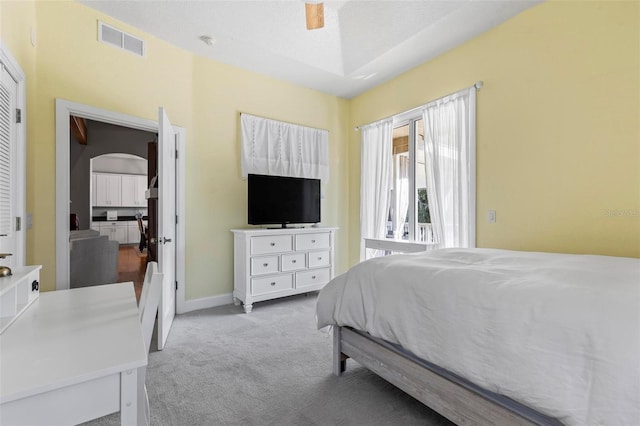 bedroom featuring a textured ceiling, light colored carpet, and ceiling fan