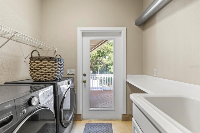 laundry area with separate washer and dryer and light tile patterned floors