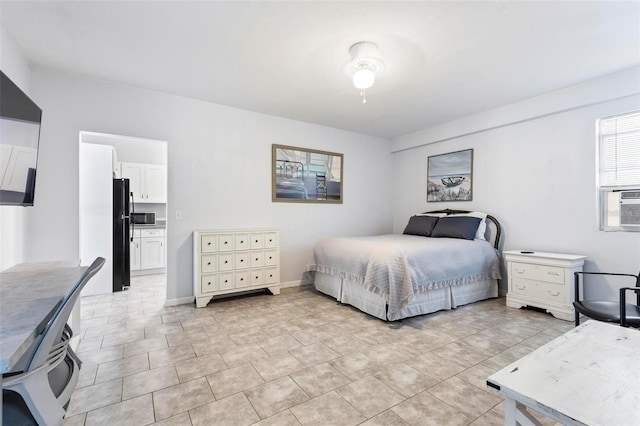 bedroom featuring black refrigerator, ceiling fan, and ensuite bath