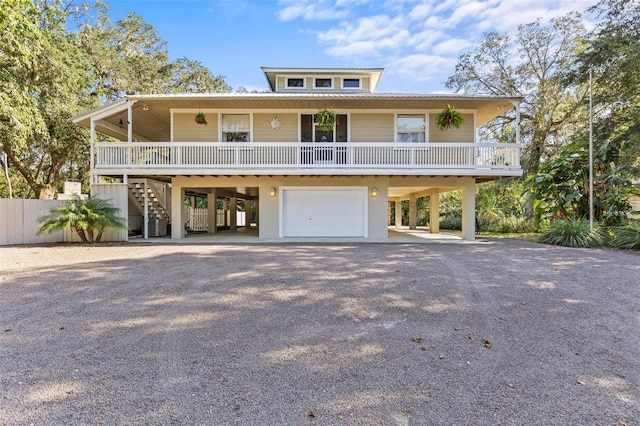 coastal inspired home featuring covered porch and a garage