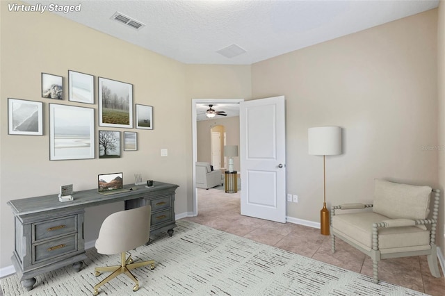 home office with light tile patterned floors, a textured ceiling, visible vents, and baseboards