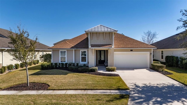 view of front facade with a garage, driveway, a front lawn, and a shingled roof