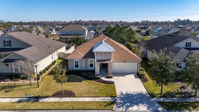 traditional home featuring concrete driveway, an attached garage, board and batten siding, a residential view, and a front lawn