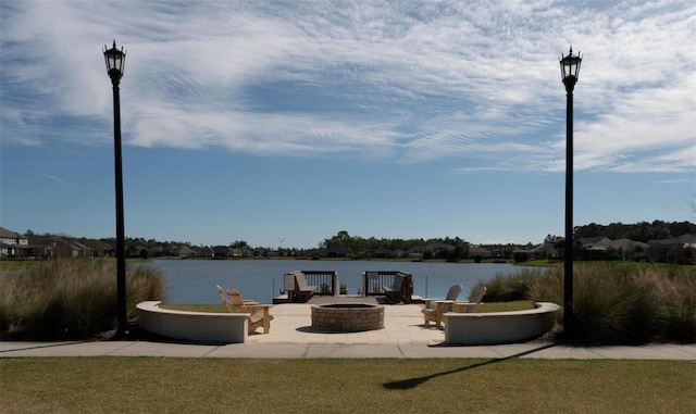 view of dock featuring a patio, a water view, and an outdoor fire pit