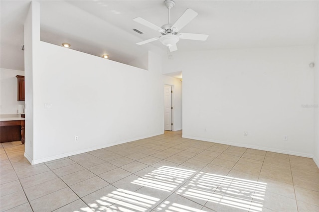 empty room featuring high vaulted ceiling, light tile patterned floors, and ceiling fan