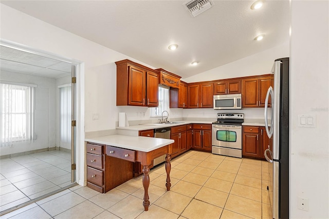 kitchen with light tile patterned flooring, stainless steel appliances, sink, and vaulted ceiling