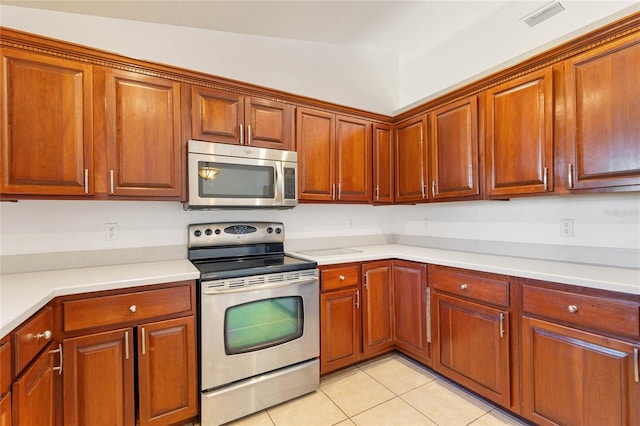 kitchen with light tile patterned floors, stainless steel appliances, and lofted ceiling