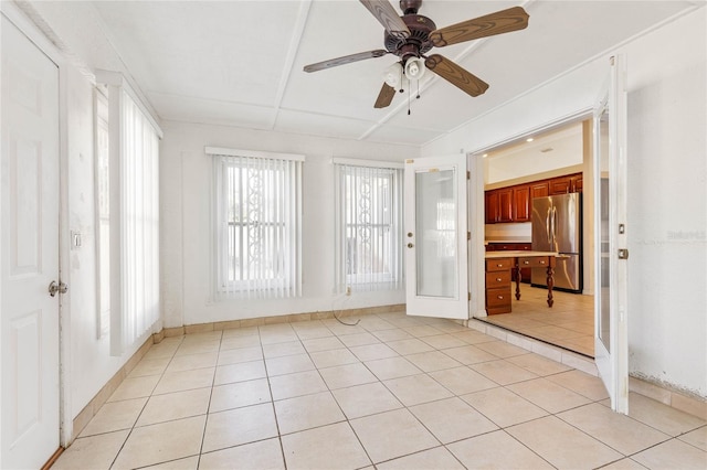 unfurnished sunroom with built in desk and ceiling fan