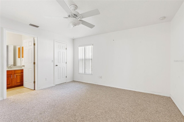 unfurnished bedroom with connected bathroom, light carpet, a closet, and ceiling fan