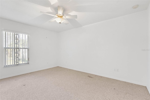 carpeted spare room featuring ceiling fan