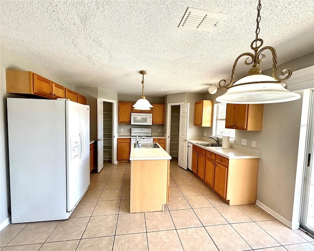 kitchen with a center island with sink, sink, decorative light fixtures, light tile patterned floors, and white appliances