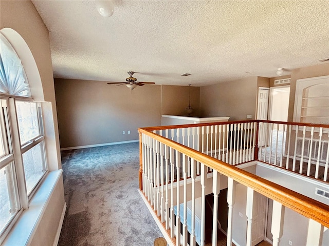 hallway with carpet floors and a textured ceiling