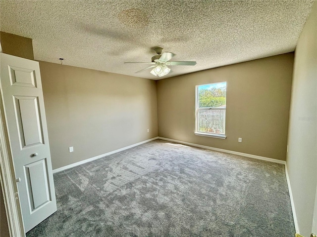 spare room featuring a textured ceiling, ceiling fan, and dark colored carpet