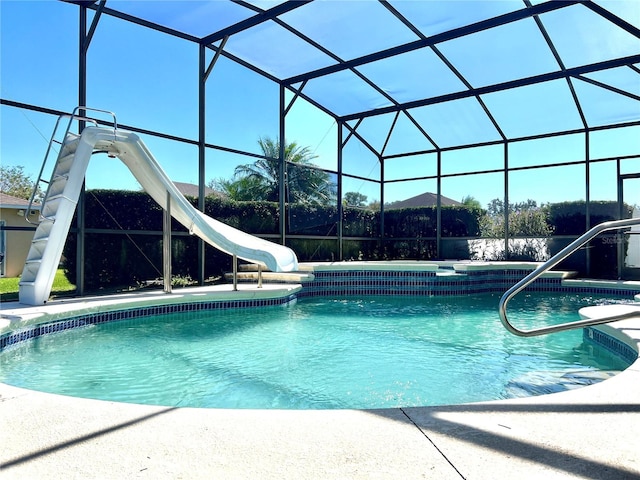 view of pool featuring a water slide and glass enclosure