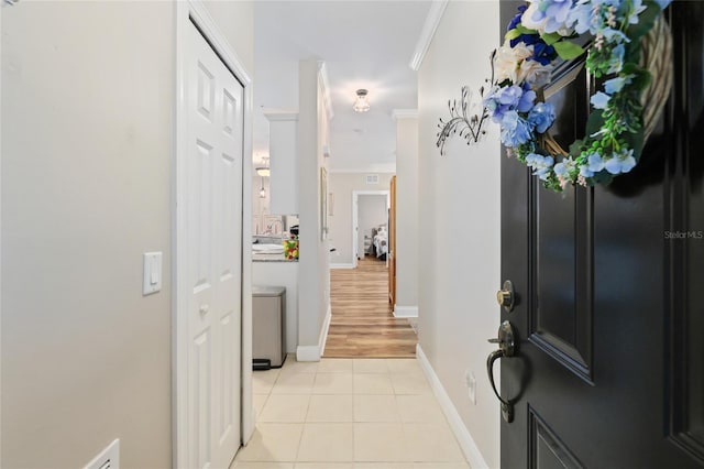 interior space featuring crown molding and light tile patterned floors